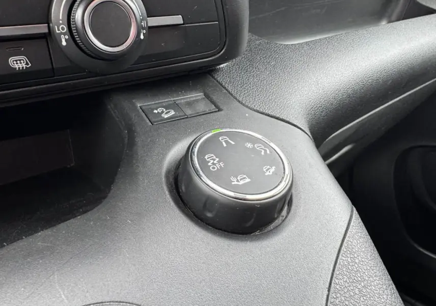 Gros plan sur la molette de contrôle des aides à la conduite dans l'habitacle noir du Citroën Berlingo blanc 2019.