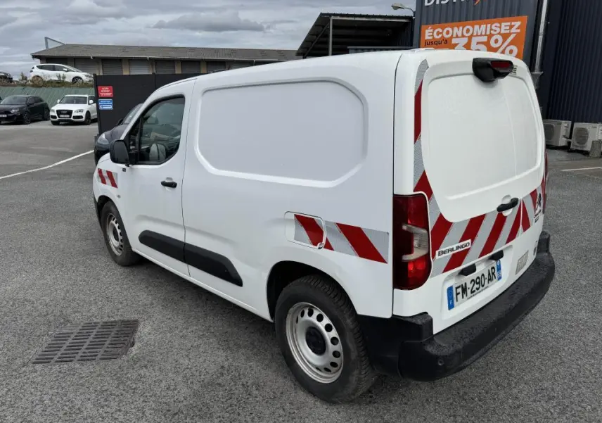 Vue 3/4 arrière droite d’un utilitaire Citroën Berlingo blanc avec bandes réfléchissantes rouges et blanches sur portes arrière.