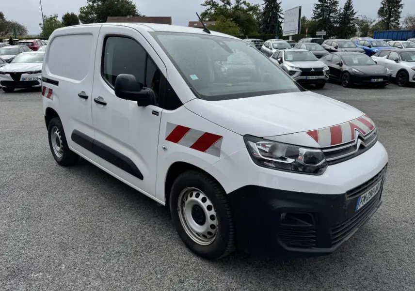 Fourgon Citroën Berlingo blanc en 3/4 avant droit avec bandes réfléchissantes rouges et blanches sur capot et ailes.