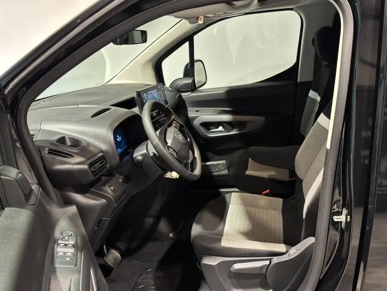 Vue intérieure côté conducteur du Citroën Berlingo noir Perla Nera nacré, avec tableau de bord et sièges en tissu Curitiba Triton Meltem.