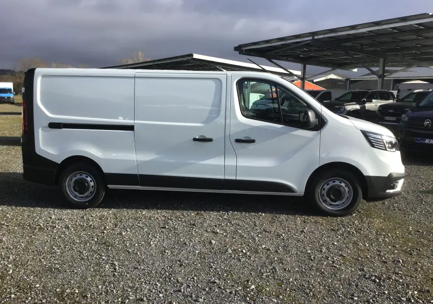 Vue latérale droite d’un Renault Trafic Fourgon blanc L2H1 2025, avec portes coulissantes et jantes acier simples.