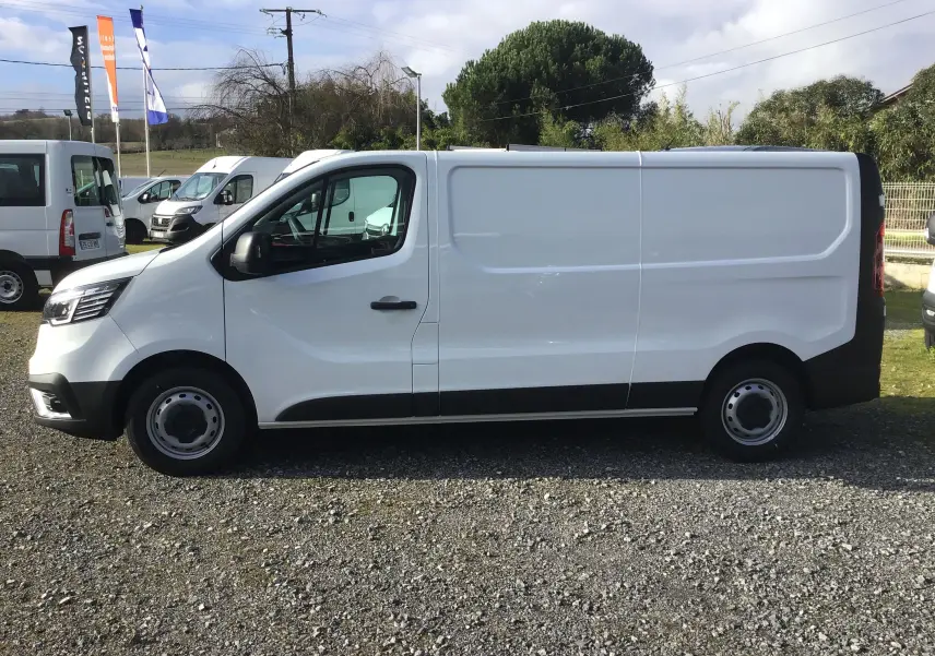 Profil droit d'un Renault Trafic Fourgon blanc 2025, avec porte latérale coulissante et jantes acier noires.