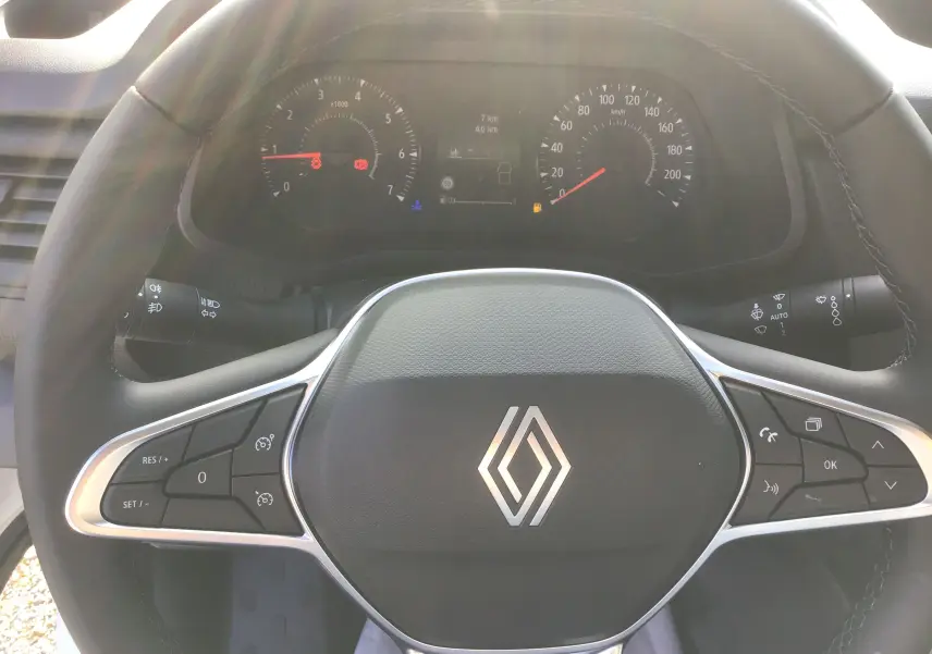 Vue rapprochée du volant noir de Renault Trafic Fourgon 2025 avec commandes intégrées et tableau de bord numérique.