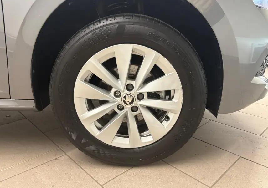 Gros plan sur la roue avant gauche d’un Skoda Kamiq 2023 gris graphite avec jante alliage à dix branches.