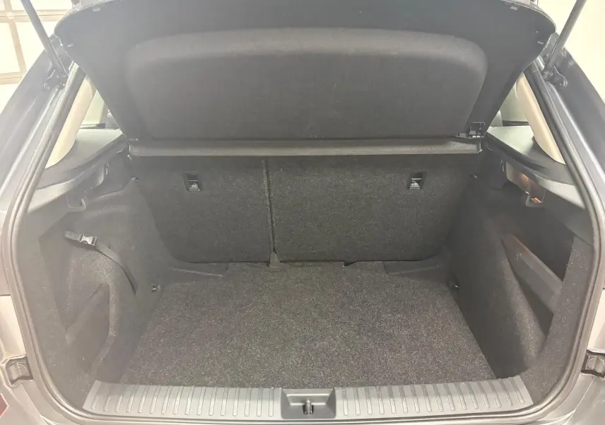 Coffre ouvert vu de l'arrière d'un Skoda Kamiq 2023 gris graphite, montrant l'espace de chargement vide et les dossiers arrière.
