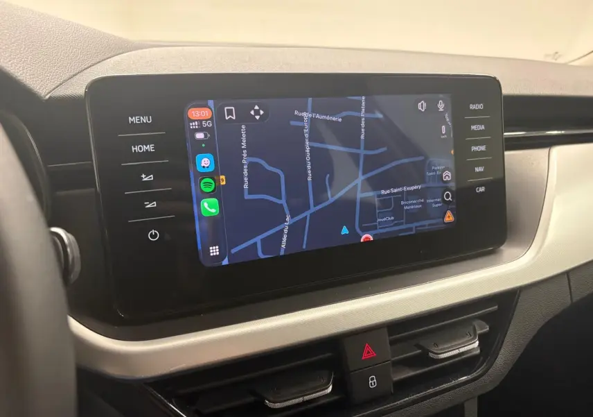 Écran tactile central du Skoda Kamiq 2023 affichant la navigation, avec commandes tactiles sur les côtés.