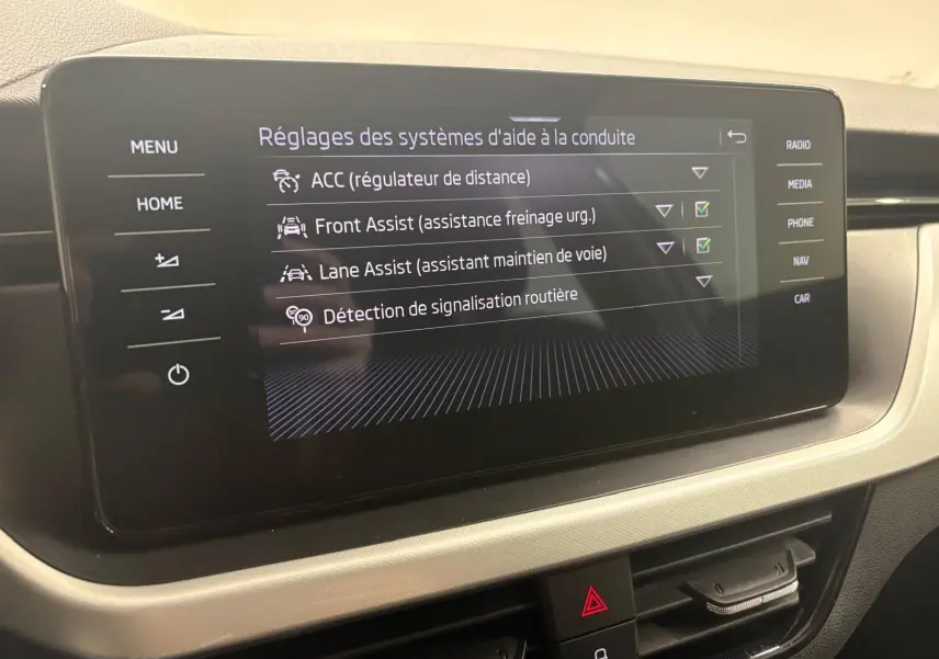 Écran central du Skoda Kamiq 2023 affichant les réglages des aides à la conduite dans l'habitacle.