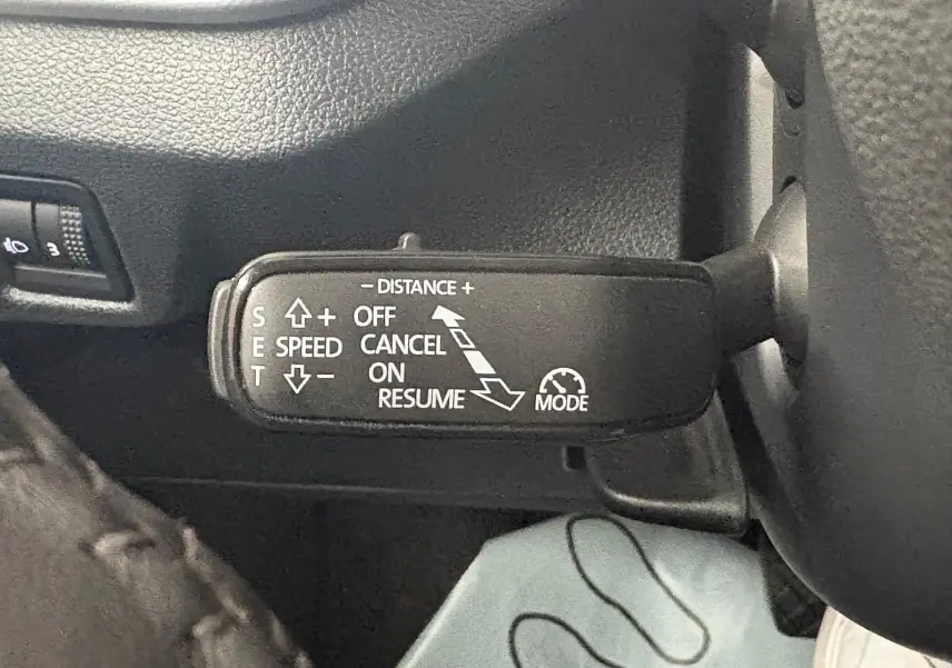 Gros plan sur la commande de régulateur de vitesse au volant d’un Skoda Kamiq gris graphite 2023.