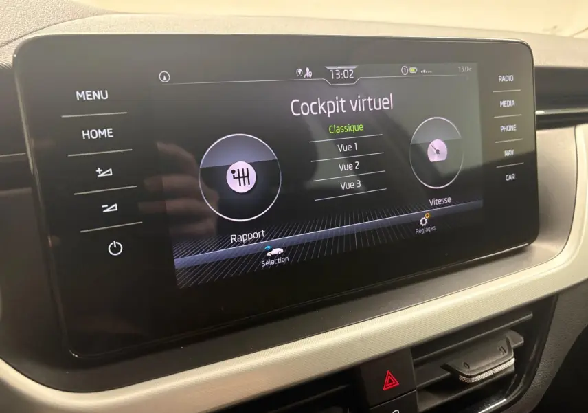 Écran tactile central du Skoda Kamiq 2023 affichant le cockpit virtuel, avec commandes et finition intérieure gris clair.