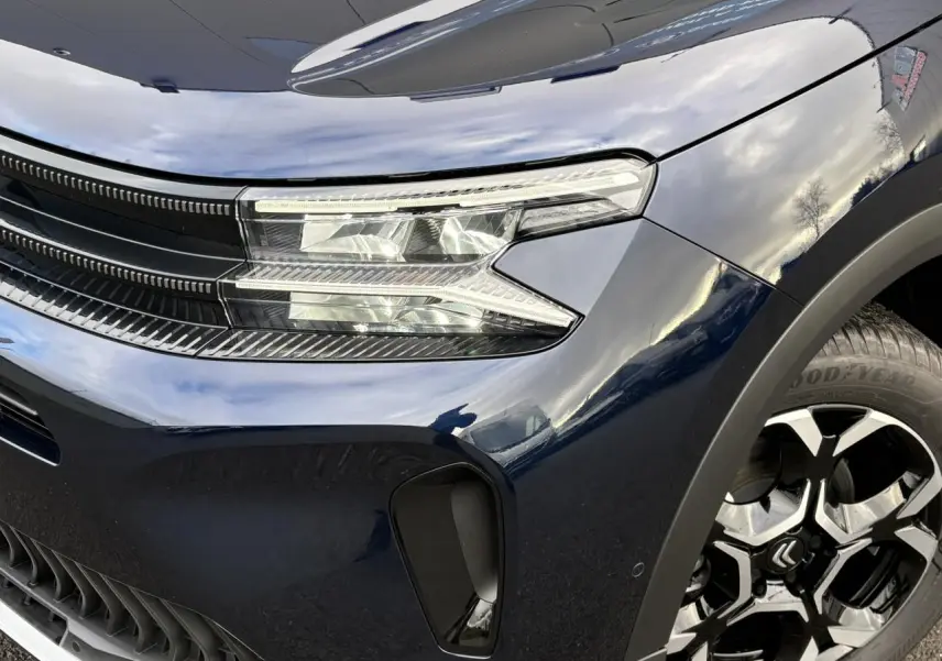Gros plan sur l'avant droit bleu Eclipse du Citroën C5 Aircross 2025, avec phares LED et jante alliage 18'' bi-ton.