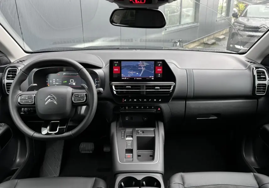 Vue intérieure avant du Citroën C5 Aircross 2025, tableau de bord noir avec écran tactile et volant multifonction.