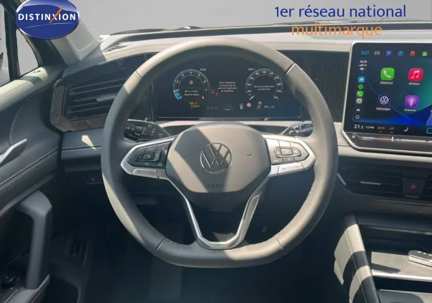 Vue intérieure centrée sur le volant noir du Volkswagen Tiguan 2026 avec tableau de bord numérique et écran tactile.