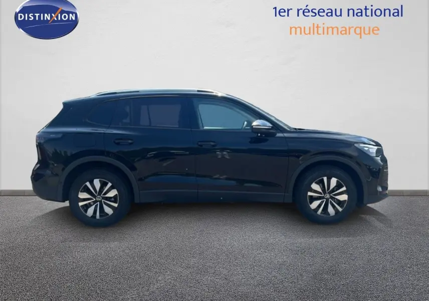 Volkswagen Tiguan noir grenadilla métal vu de profil côté gauche, avec jantes distinctives et toit ouvrant.