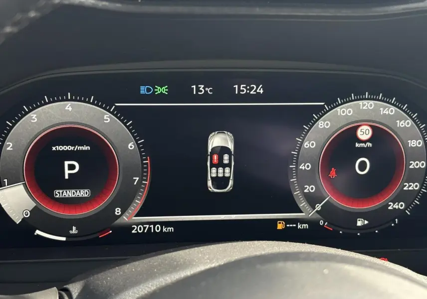 Tableau de bord numérique du Nissan Juke 2025 affichant la vitesse, régime moteur et alertes, vue frontale rapprochée.