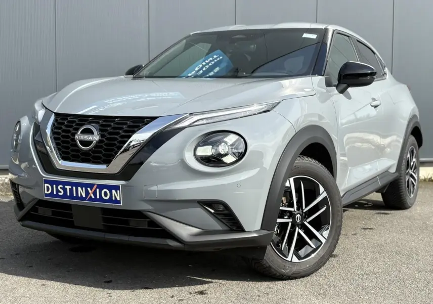Nissan Juke gris Ceramic en 3/4 avant droit, avec calandre chromée et jantes alliage noires et argentées.