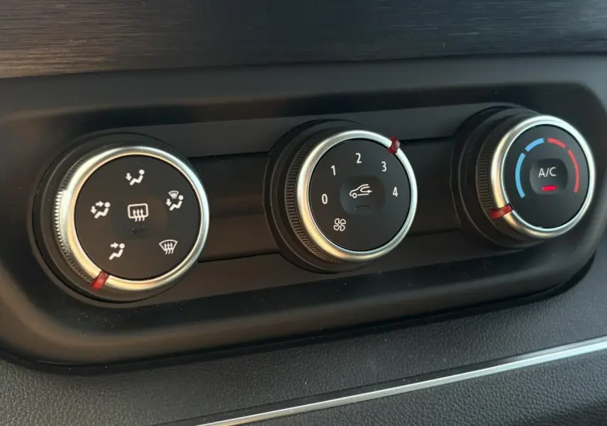 Gros plan sur les commandes de climatisation du Nissan Primastar Combi noir Minuit, avec réglages ventilation et A/C.