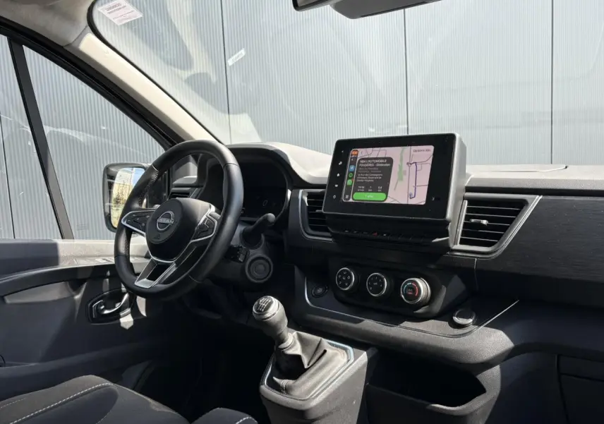 Vue intérieure côté conducteur du Nissan Primastar Combi 2025, tableau de bord avec écran tactile et boîte manuelle.