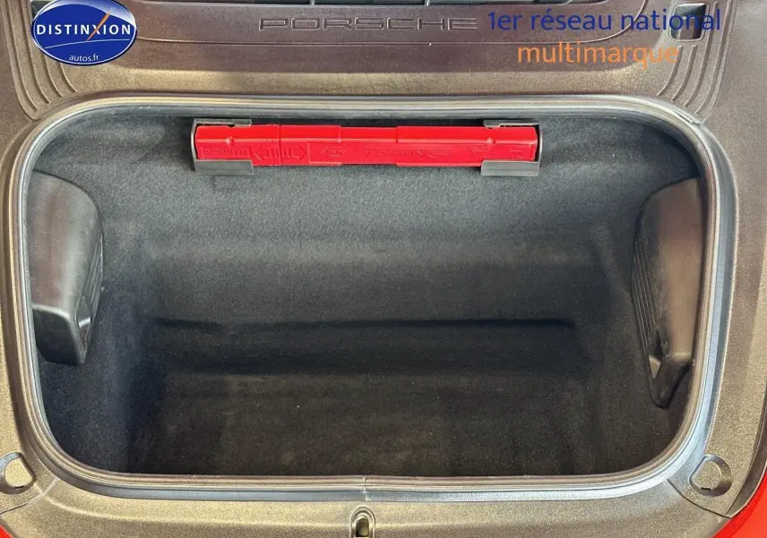 Coffre avant ouvert d'une Porsche 911 rouge (991) Carrera 4 PDK, montrant un espace de rangement vide et propre.