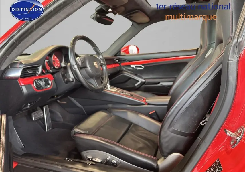 Intérieur noir et rouge de la Porsche 911 (991) Carrera 4 PDK vu côté conducteur avec volant cuir multifonction.