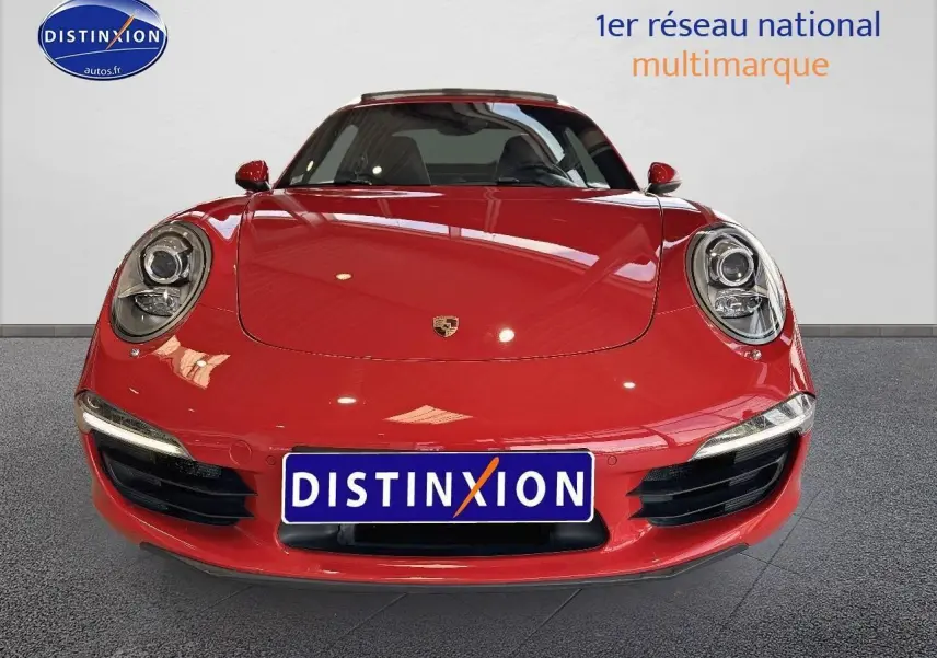Vue frontale d'une Porsche 911 (991) Carrera 4 PDK rouge avec phares ronds et plaque Distinxion.