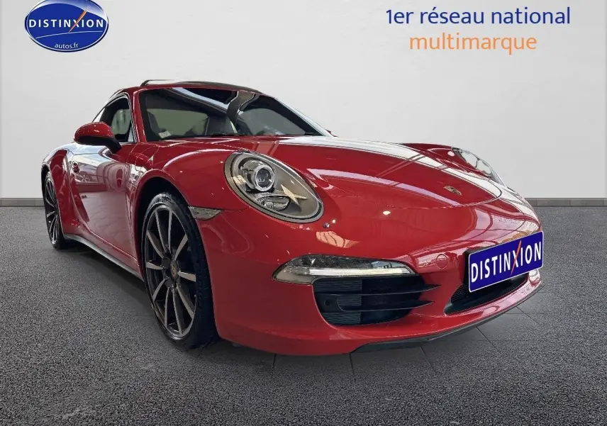 Porsche 911 (991) Carrera 4 rouge vue en 3/4 avant avec jantes alu et phares bi-xénon allumés.