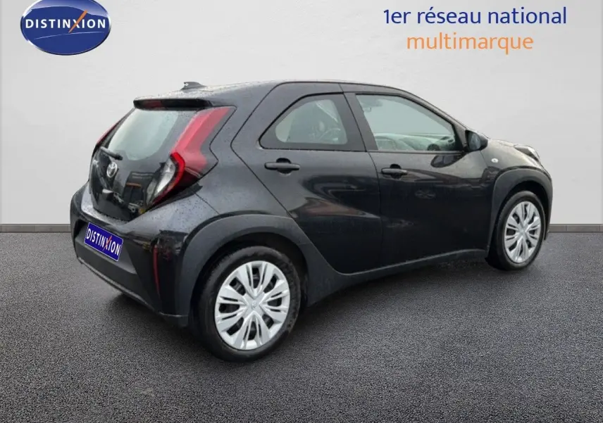 Vue 3/4 arrière droite d'une Toyota Aygo X noire 2025 avec feux arrière en forme de C et jantes argentées.