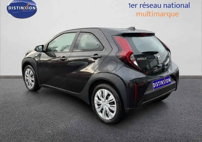 Vue 3/4 arrière droite d'une Toyota Aygo X noire 2025, compacte avec feux arrière en forme de boomerang.