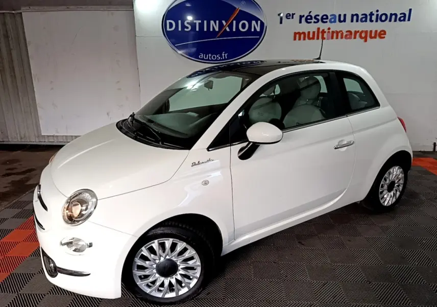 Vue 3/4 avant droite d'une FIAT 500 Dolcevita blanche avec jantes argentées et toit noir brillant.