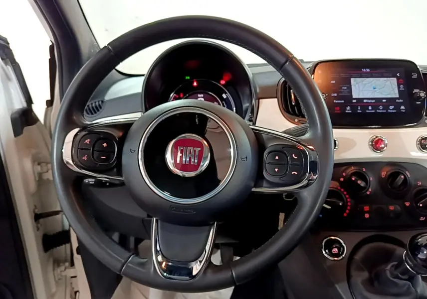 Vue intérieure centrée sur le volant cuir noir et le tableau de bord blanc de la Fiat 500 Hybrid 2021.