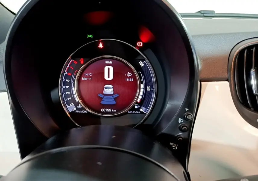 Vue rapprochée du tableau de bord numérique de la Fiat 500 blanche, affichant 0 km/h et 60199 km au compteur.