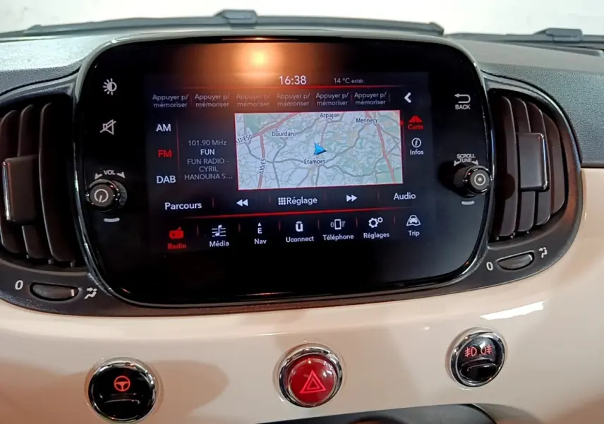 Écran tactile central avec navigation affichée sur tableau de bord beige de Fiat 500 Hybrid blanc, vue intérieure frontale.