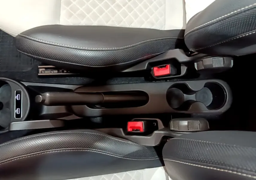 Vue plongeante sur la console centrale noire de la Fiat 500 Hybrid 2021 avec sièges cuir noir et blanc et frein à main manuel.
