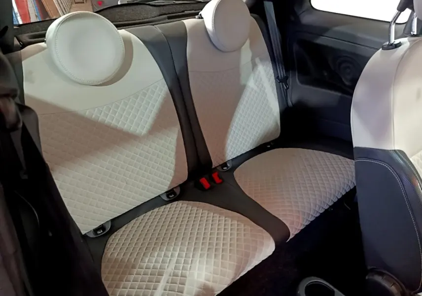 Vue intérieure montrant la banquette arrière beige matelassée de la Fiat 500 Hybrid 2021 avec appuie-têtes ronds.