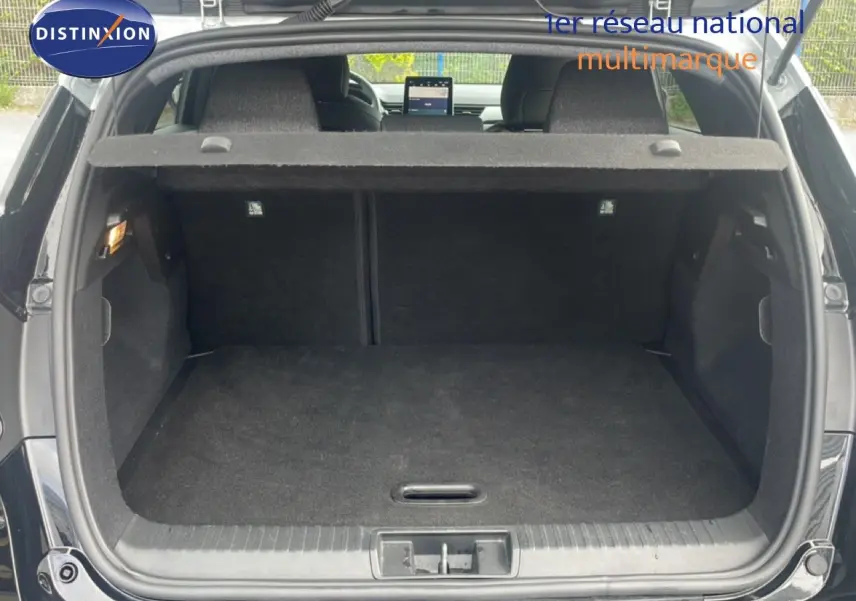 Coffre ouvert vu de l'arrière d'un Renault Captur noir étoile métal avec toit gris, montrant l'espace de chargement vide.