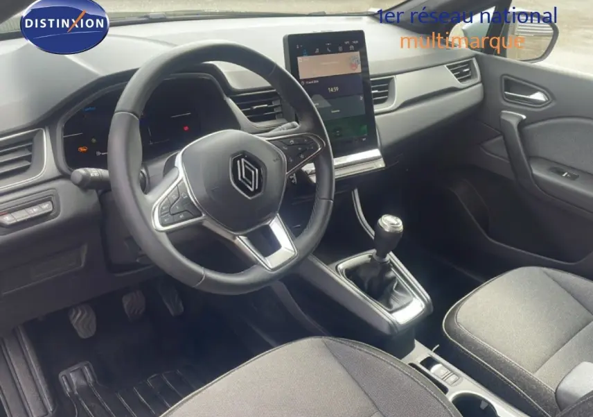 Vue intérieure avant droite du Renault Captur 2025, volant multifonction, écran tactile vertical et levier de vitesse manuel.
