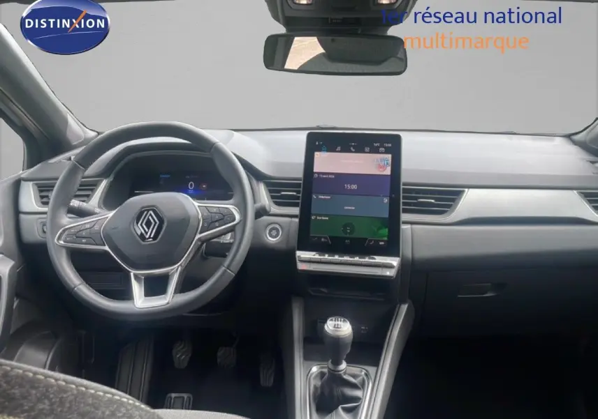 Vue intérieure avant du Renault Captur 2025, tableau de bord moderne avec écran tactile vertical et levier de vitesse manuel.