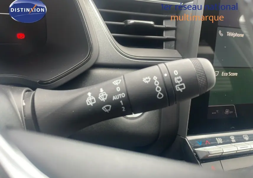 Gros plan sur la commande d’essuie-glace à gauche du volant dans l’habitacle du Renault Captur noir étoile métal avec toit gris.