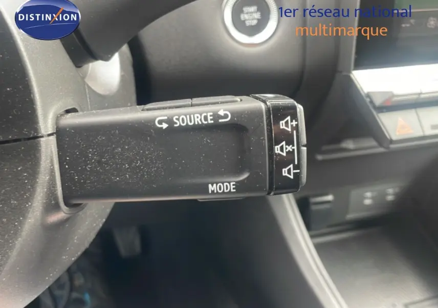 Gros plan sur la commande audio au volant du Renault Captur 2025 noir étoile métal avec toit gris, intérieur moderne.