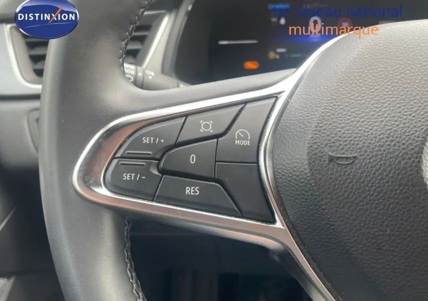 Gros plan sur les commandes au volant côté gauche du Renault Captur noir étoile métal avec toit gris, version 2025.