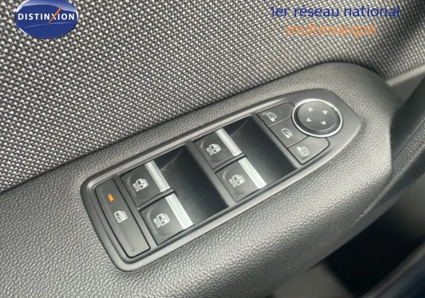 Gros plan sur les commandes des vitres électriques et rétroviseurs côté conducteur du Renault Captur noir étoile métal toit gris.
