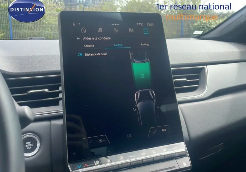 Intérieur du Renault Captur 2025, écran tactile central affichant les aides à la conduite, tableau de bord gris et noir.