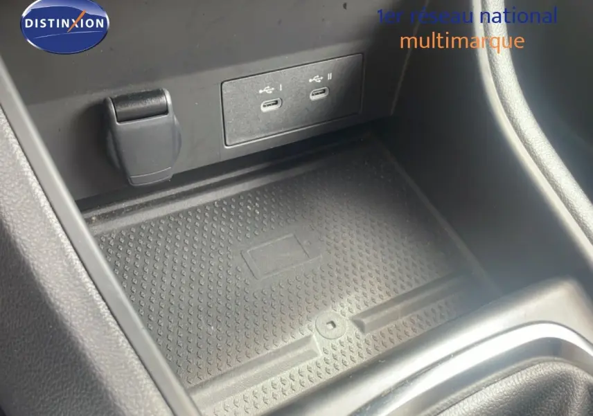Gros plan sur la console centrale du Renault Captur 2025, montrant les ports USB et un espace de rangement noir texturé.