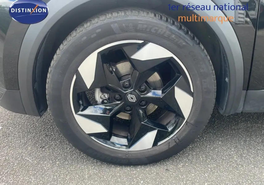 Gros plan sur la roue avant droite du Renault Captur noir étoile métal avec jante bi-ton gris et noir.