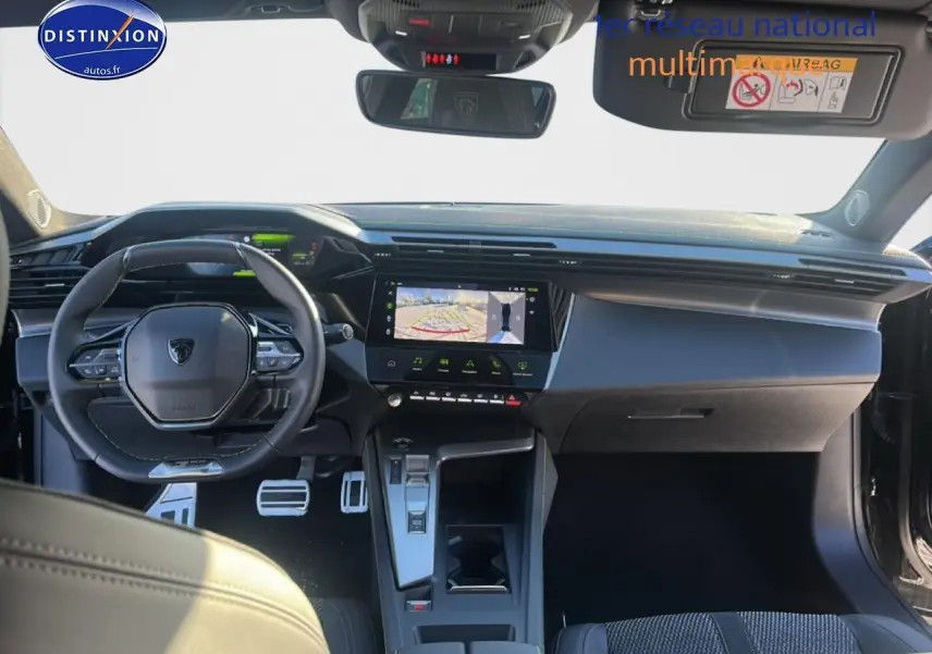 Intérieur Peugeot 408 Hybrid 2025 vu de face, tableau de bord noir avec écran tactile et volant cuir multifonctions.