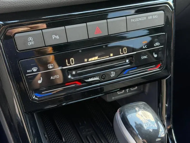 Gros plan sur la console centrale noire du Volkswagen T-Cross 2026, affichant la climatisation automatique bi-zone et levier de vitesse.