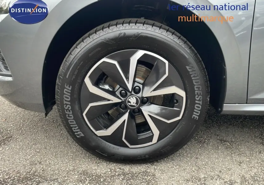 Gros plan sur la roue avant gauche d'un Skoda Kamiq gris graphite avec jante alliage bicolore et pneu Bridgestone.