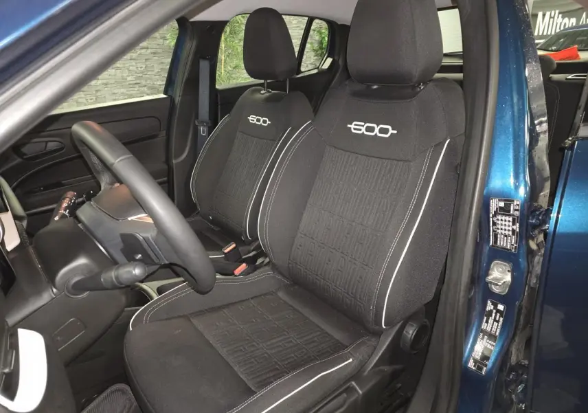 Vue intérieure côté conducteur de la FIAT 600 2024 bleu, sièges tissu noir avec logo "600" brodé blanc.