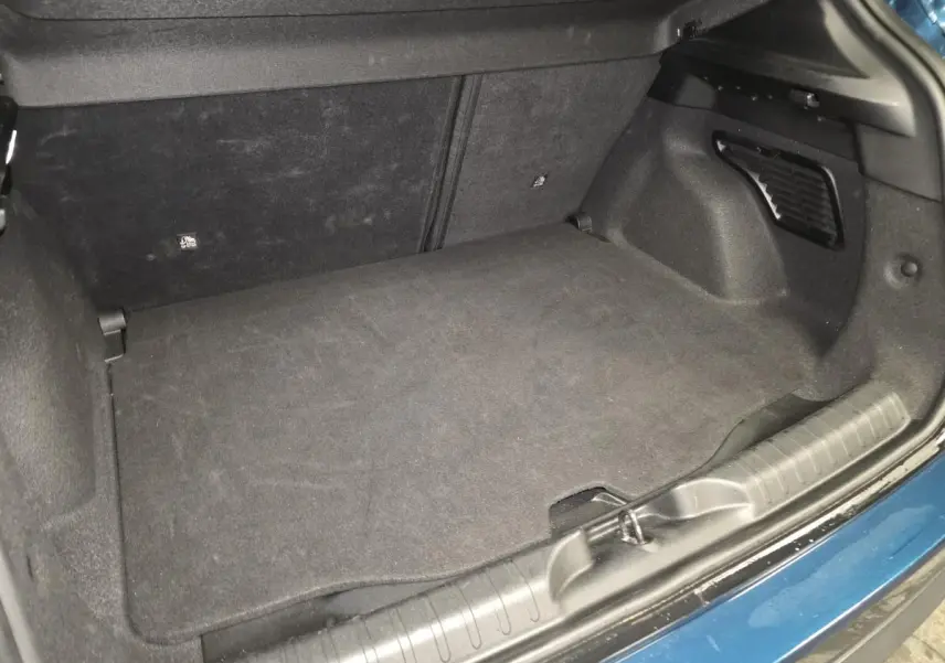 Vue rapprochée du coffre modulable bleu métallisé du FIAT 600 Hybrid 2024, montrant le plancher et les finitions intérieures.