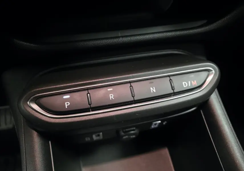 Gros plan sur la commande de boîte automatique noire de la FIAT 600 Hybrid 2024, boutons P, R, N et D/M éclairés.