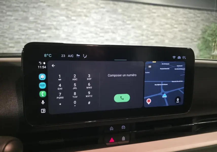 Écran tactile central affichant un clavier de numérotation et une carte GPS dans l'habitacle d'une Fiat 600 bleu.